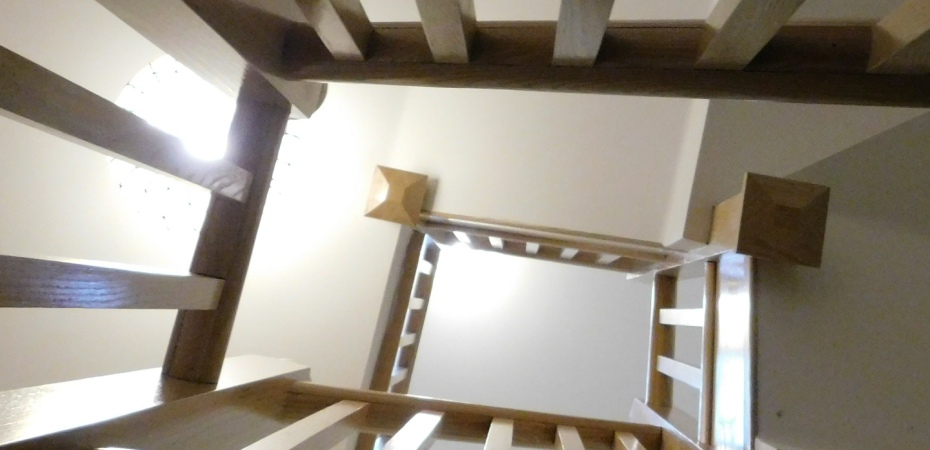 Looking upwards through a hall that passes three flights of stairs.